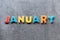 January word written with colorful letters on grey granite stone background