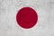 Japan flag painted on an old grunge wall. texture scratched backdrop and concept of flag day. national symbol has red circle on a