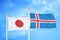 Japan and Iceland two flags on flagpoles and blue cloudy sky