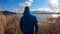 Japan - A man walking in between golden grass at the shore of Kawaguchiko Lake with the view on Mt Fuji