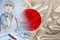 Japan national flag on satin, doctor with syringe, country population vaccination concept, medical development, covid-19