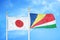 Japan and Seychelles two flags on flagpoles and blue cloudy sky