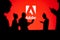 JAPAN, TOKYO. JANUARY 30, 2023: Adobe. Collaborating for Innovation: Silhouetted Web Developers in Action with Company Logo in