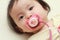 Japanese baby girl sucking on a pacifier