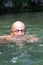 Japanese bald head guy emerging from water