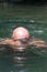 Japanese bald head guy emerging from water