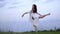 Japanese ballerina in a graceful pose is standing on one leg on the lawn, slow motion