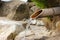 Japanese bamboo pipe hot spring water flowing into onsen pool.