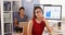 Japanese businesswoman sitting at desk with colleague in Mexican background