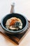 Japanese Chashu Don: Steam Rice topping with Roasted Pork Belly, Yolk, Dried Seaweed and Saffron. Served in black ceramic bowl