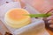 Japanese Cheesecake cut by green knife in opened paper box. Soft and sweet