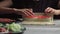Japanese chef prepares sushi rolls with salmon and avocado. Cook hands making Japanese sushi roll on the bamboo mat