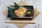 Japanese chicken grilled with sea salt served with sliced lemon and wasabi in stone rectangle plate with chopstick on makisu.