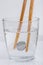 Japanese coin yen holding by wooden chopsticks in a glass of w