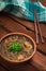 Japanese cuisine, soup with chashu pork, chives, sprouts, noodles and seaweed on the table under the sunlight. Wooden rustic backg