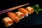 Japanese cuisines nigiri sushi set on black plate served with wasabi, soy sauce. Sushi Roll with salmon, sushi maki roll and