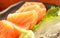 Japanese food: salmon sashimi fresh raw salmon meat decorated with grated turnip and mint leaf on wooden table as a background