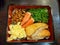 Japanese food style, Top view of grilled salmon steak, omelet, wakame seaweed, minced pork with sauce, crab stick topped on rice