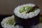 Japanese food with a thick roll futomaki, which is filled with vegetables, rice and algae leaves encased