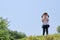 Japanese girl blowing dandelion seeds under the blue sky