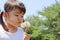 Japanese girl blowing dandelion seeds under the blue sky