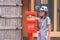 Japanese girl is send a postcard into the vitnage red mailbox