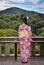 Japanese girl viewing a temple on wooded hillside