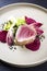Japanese gourmet fried tuna fish steak tataki with pak choi, witloof and red beet on a modern Nordic design plate
