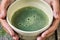 Japanese green matcha tea in a special clay bowl in girl`s hands