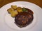 Japanese Hamburger steak with Demi Glace Sauce with roasted potatoes on white plate, serving portion, high angle view