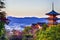 Japanese Heritage. Renowned Kiyomizu-dera Temple Pagoda Against Kyoto Skyline  and Traditional Red Maple Trees in Background in