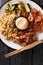 Japanese hibachi lunch made of fried rice, shrimp, steak and vegetables close-up on the table. Vertical top view