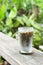 Japanese hojicha latte machiato coffee in the glass on wooden table