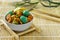 Japanese hot snacks with peanuts and wasabi lie in a white glass bowl on a wooden stand on a bamboo lining