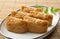 Japanese Inari Sushi on a plate set against a wooden backdrop