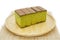 Japanese Matcha green tea cake cheesecake on wooden plate and traditional mat