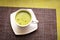 Japanese matcha green tea is poured into a white mug and on a white saucer in powder. Tea set on a textured napkin. Invigorating d