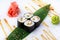 The Japanese menu. Delicious fresh mini-rolls with cucumber, eel and cheese on a banana leaf. Sushi rolls on a white background wi