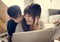 Japanese mother and son watching family photo album in living room