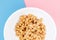 Japanese natto beans in a white bowl close-up on pink and blue background