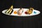 Japanese Nigiri Sushi with avocado, Sake salmon Tataki and Tamagoyaki omelette. white plate with colourful food decoration paints