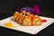 Japanese no rice sushi roll with tempura shrimp wrapped in carrot slices served with flowers, painting brush strokes