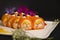 Japanese no rice sushi roll with tempura shrimp wrapped in carrot slices served with flowers, painting brush strokes