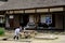 A Japanese old lady watering the plant in front of the shop in Ouchi-juku, Tohoku region, Japan