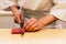 Japanese Omakase Chef cut bluefin tuna Otoro in Japanese neatly by knife on wooden kitchen counter for making sushi.