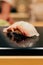 Japanese Omakase meal: Close up Tai Sea Bream fish Sushi served on glossy black plate. Japanese luxury meal