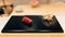 Japanese Omakase meal: Otoro Bluefin Tuna Sushi served by hand with pickled ginger on glossy black plate. Japanese luxury meal