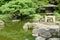 Japanese outdoor stone lantern, green plants in zen garden