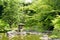 Japanese outdoor stone lantern, green plants in zen garden