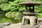 Japanese outdoor stone lantern and lake in zen garden